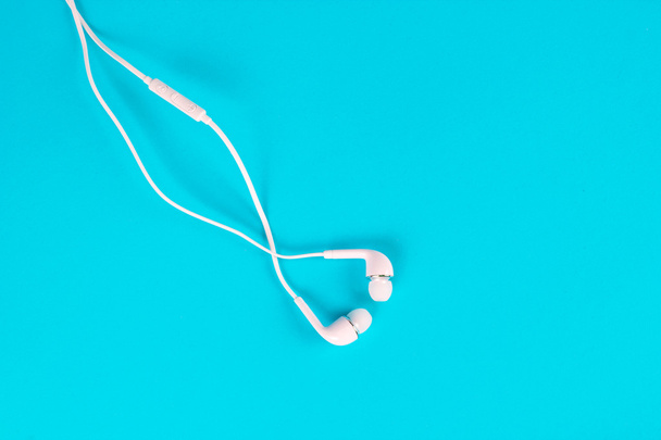 λευκά ακουστικά για τη χρήση της ψηφιακής μουσικής ή έξυπνο τηλέφωνο - Φωτογραφία, εικόνα