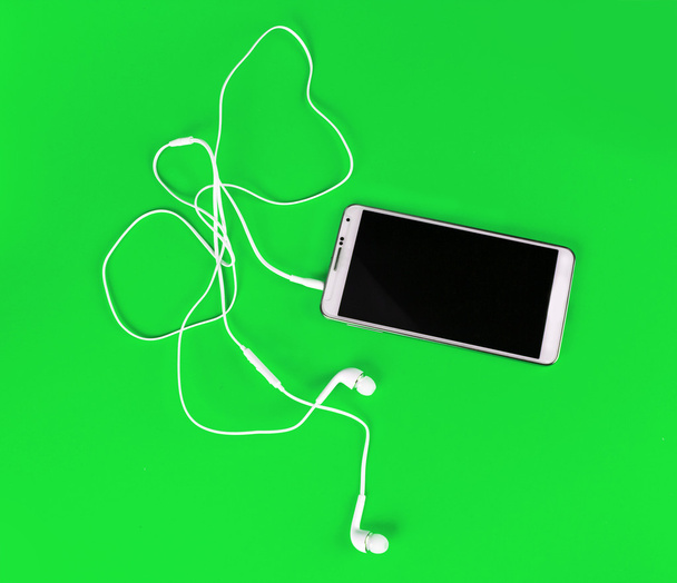 fehér fülhallgató részére használ szúró telefon és digitális zene - Fotó, kép