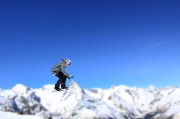 Lentävä lumilautailija vuorilla
 - Valokuva, kuva