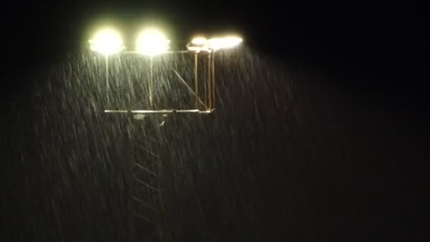 Προβολείς σταδίου τη νύχτα κατά τη διάρκεια ενός βαρέως ντους ψιλής βροχής. - Πλάνα, βίντεο