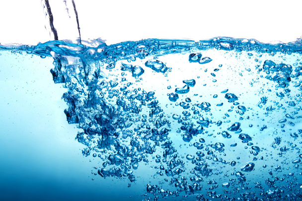 Nahaufnahme blauer Wasserspritzer mit Blasen auf weißem Hintergrund - Foto, Bild