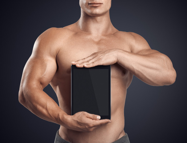 Fitness male holding vertically digital tablet with blank screen - Foto, Imagem