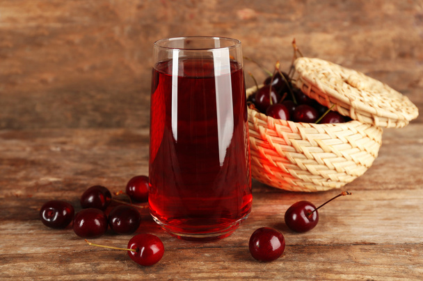 Glass of cherry juice on wooden background - Фото, зображення
