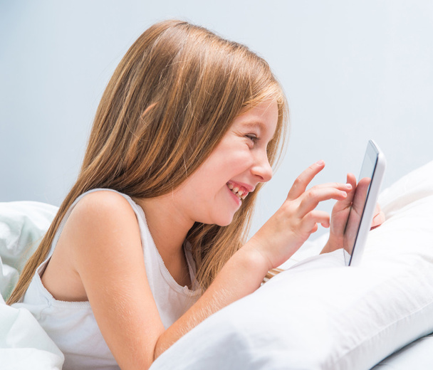 schoolgirl with tablet in bed at  - Photo, Image