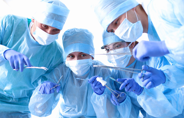 Команда хирургов за работой в операционной
 - Фото, изображение