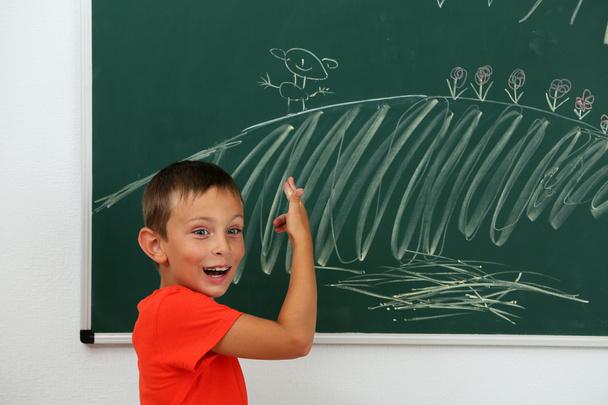Boy drawing on blackboard - Фото, зображення
