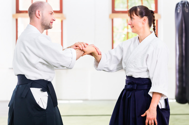 Homme et femme combattant à l'école d'arts martiaux d'Aïkido
 - Photo, image
