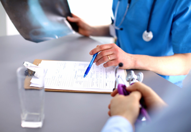 Médico médico sentado en la mesa y mirando pacientes roentgen
 - Foto, Imagen