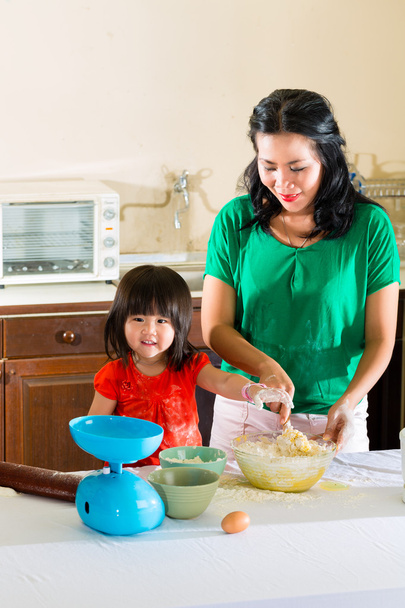 Asiática madre e hija en casa en cocina
 - Foto, imagen