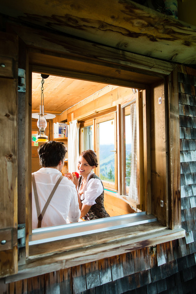 Young couple in a hunter's cabin eating - Foto, imagen
