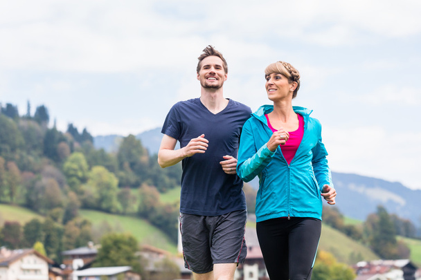 Paar treibt Sport beim Laufen in den Bergen - Foto, Bild