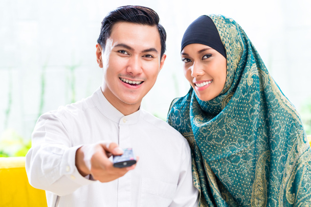 Asiatique Musulman Couple commutation TV avec télécommande
 - Photo, image