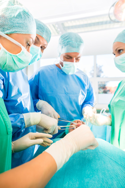 Cirujanos operando paciente en quirófano - Foto, Imagen