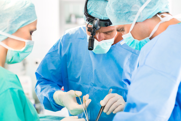 手術室で患者を手術する外科医 - 写真・画像