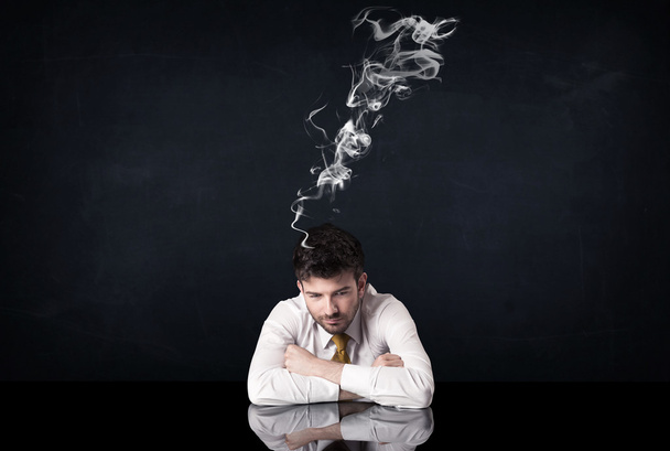 Депрессивный бизнесмен с дымящейся головой - Фото, изображение