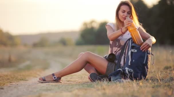 Beautiful young woman journalist in the steppe. Girl with camera on nature. A young woman with a camera on a safari. Travel, tourism, adventure. - Imágenes, Vídeo