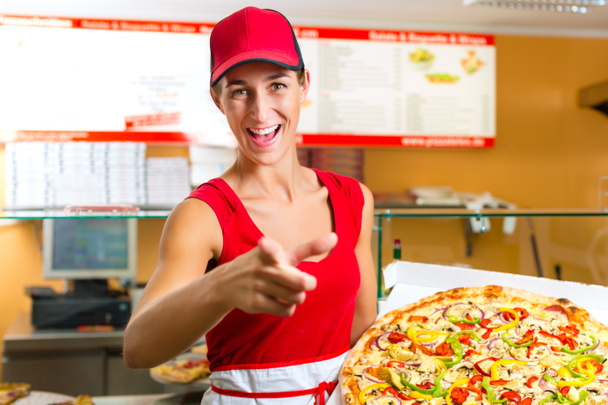 Woman holding a whole pizza in hand - Foto, Imagen