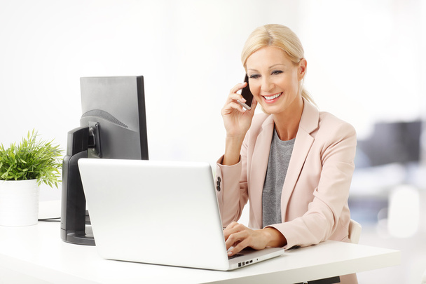 mulher fazendo chamada enquanto sentado no escritório
 - Foto, Imagem