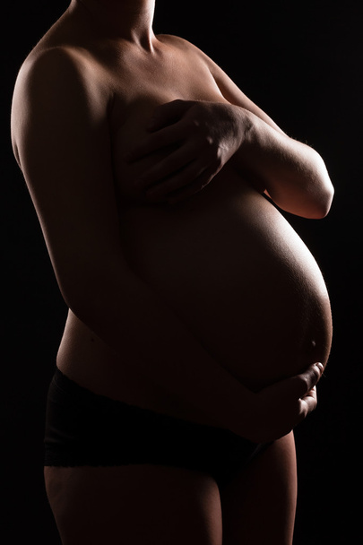 Έγκυος γυναίκα γυμνή αγγίζοντας την κοιλιά ή μωρό χτύπημα - Φωτογραφία, εικόνα
