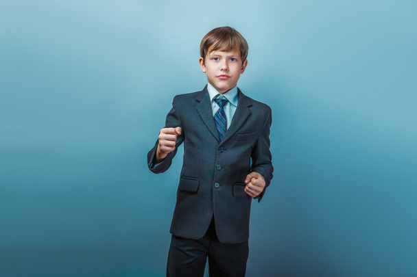 a boy of twelve European appearance in a suit shows his fists on - Foto, immagini
