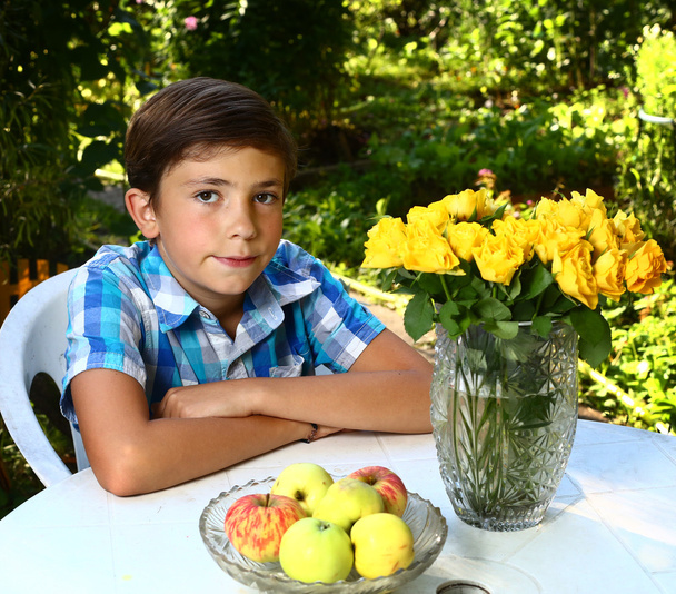  chlapec s růží na kvetoucí zahrady pozadí - Fotografie, Obrázek