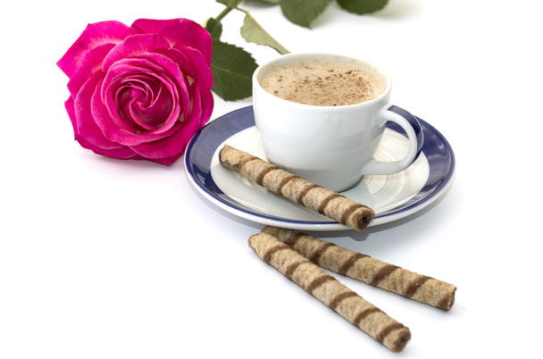 Rose and cappuccino on a saucer with a blue border - 写真・画像