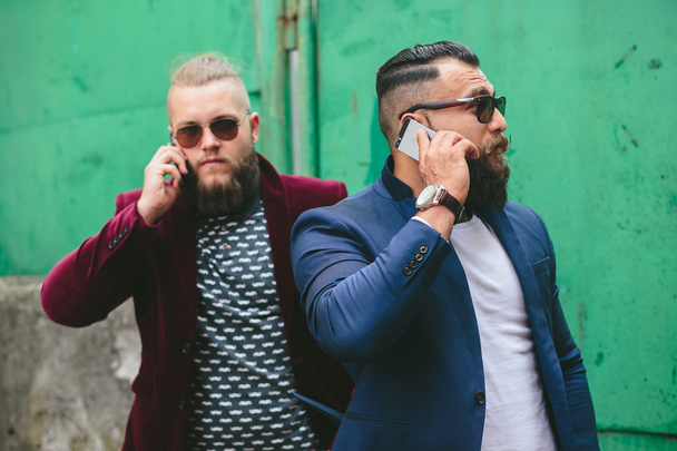 Two bearded businessman looking at phone - Foto, afbeelding