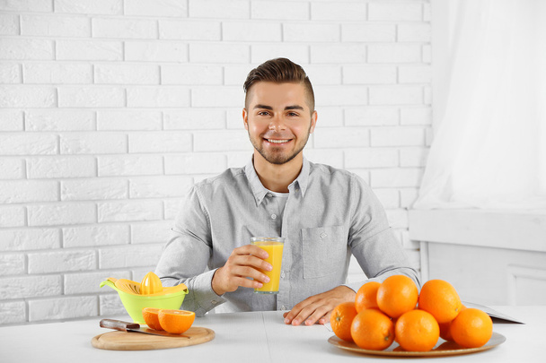 Young man drinking orange juice - Zdjęcie, obraz