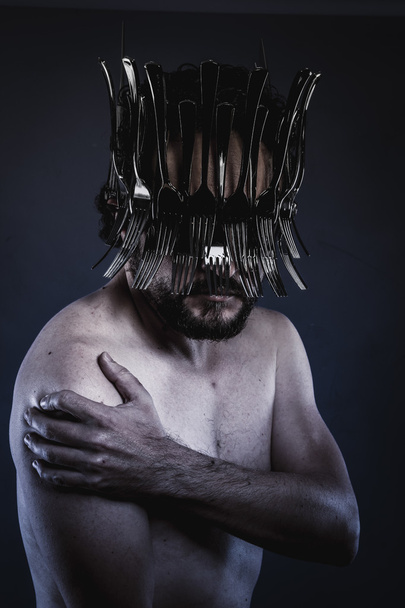 man with a crown of forks and knives - Foto, afbeelding