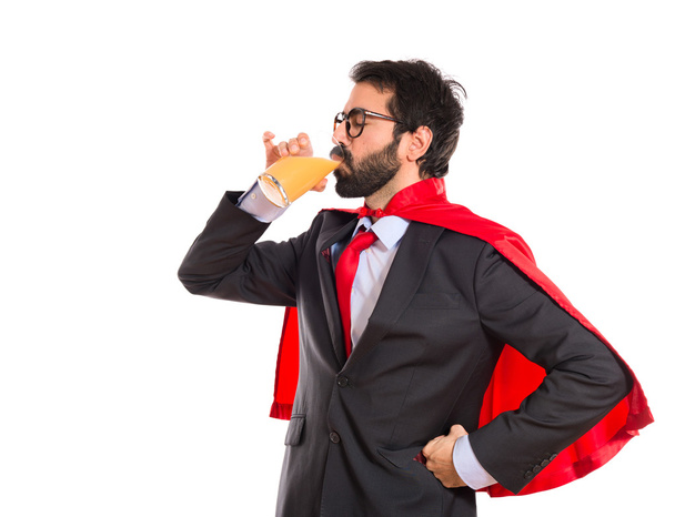 Hipster επιχειρηματίας ντυμένος σαν υπερήρωα πίνοντας χυμό πορτοκαλιού - Φωτογραφία, εικόνα