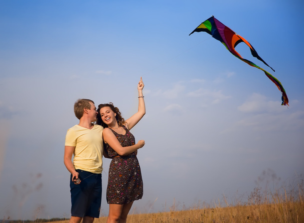 feliz jovem casal apaixonado por voar um papagaio no campo
 - Foto, Imagem