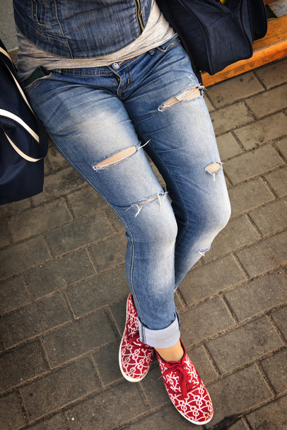 ragazza in jeans strappati seduto sulla panchina
 - Foto, immagini