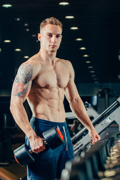 Male athlete with a dumbbell in the gym lean on row - Fotografie, Obrázek