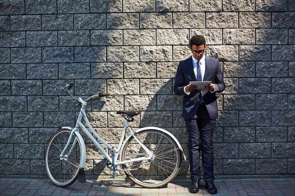 homem de negócios com touchpad e bicicleta
 - Foto, Imagem