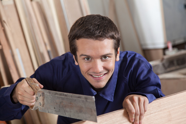 Happy man using a saw - Photo, Image