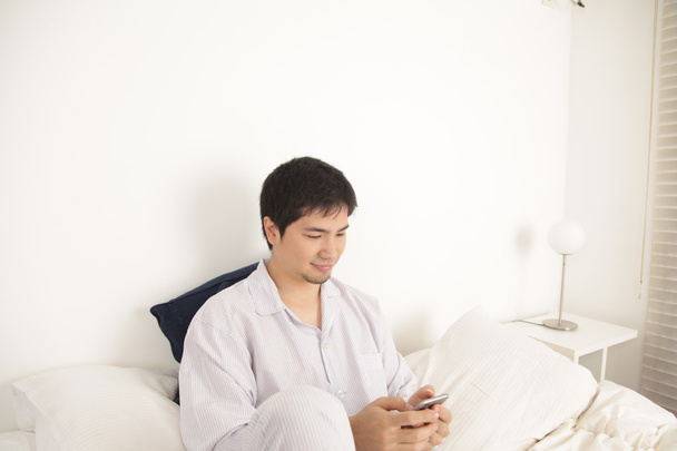 Homem asiático usando telefone celular
 - Foto, Imagem