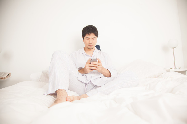 Homem asiático usando telefone celular
 - Foto, Imagem