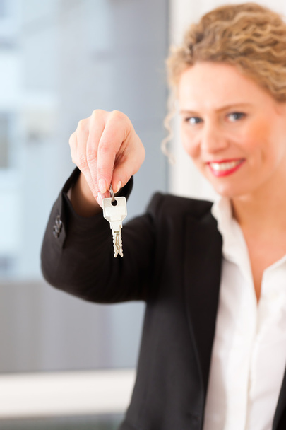 Fiatal ingatlanügynök van egy lakásban kulcsokkal - Fotó, kép