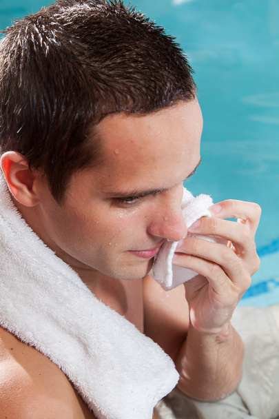 Hombre con una toalla dentro de la piscina
 - Foto, imagen