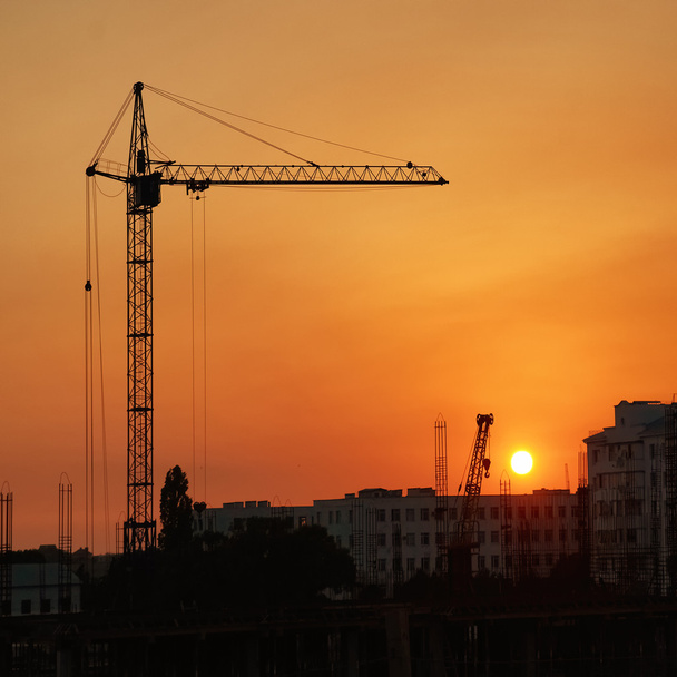 Průmyslové jeřáby nad západem slunce - Fotografie, Obrázek