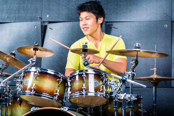 Азиатский музыкант-барабанщик в студии звукозаписи
 - Фото, изображение