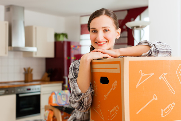 Mulher com caixa em movimento em sua casa
 - Foto, Imagem
