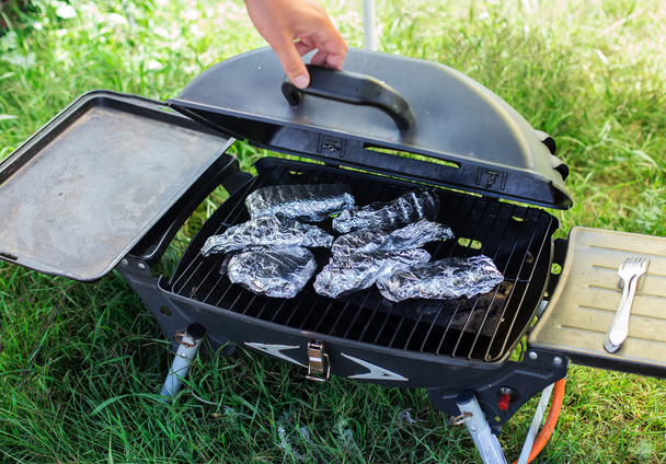 Cooking fish in foil on barbecue.  - Photo, Image