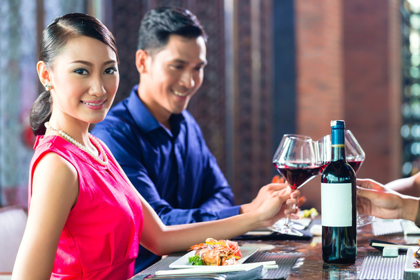 Asiatische Freunde stoßen im Restaurant mit Wein an - Foto, Bild