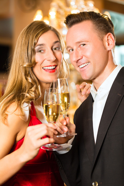 Man and woman tasting Champagne in restaurant - Fotoğraf, Görsel