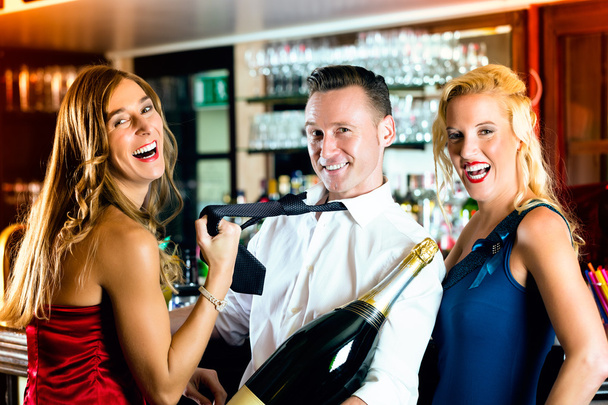 Amigos felices con una botella de champán en el bar
 - Foto, imagen