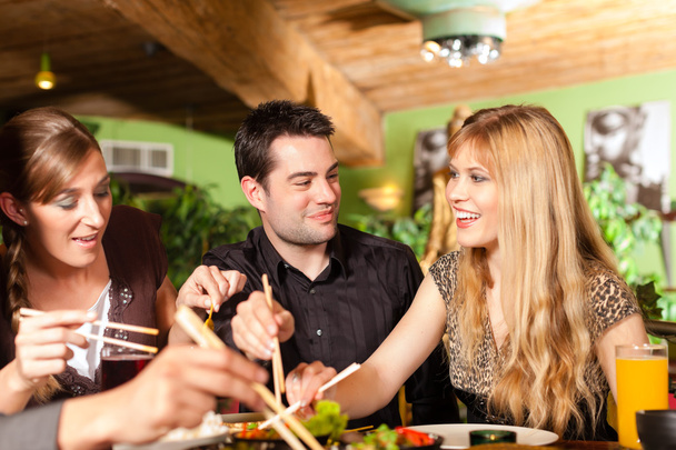 Young people eating in Thai restaurant - Photo, image