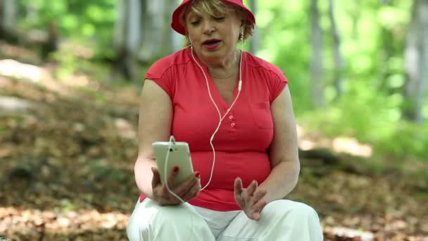 Žena komunikuje přes smartphone - Záběry, video