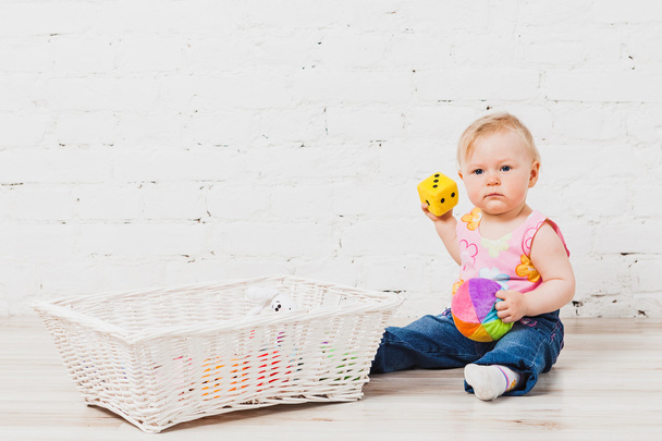Leuke babymeisje zit met speelgoed - Foto, afbeelding