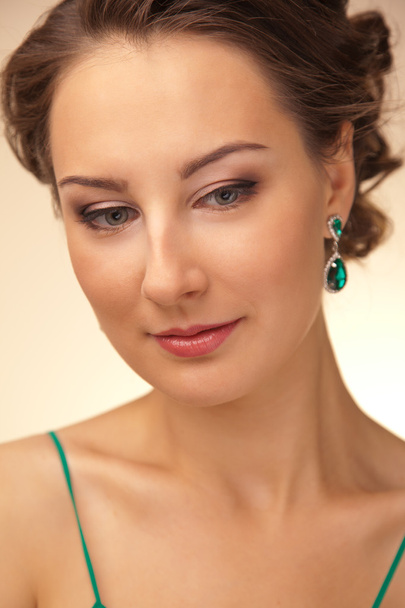 Portrait de belle femme avec des boucles d'oreilles vertes
 - Photo, image